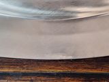 a large metal pan on a wooden table with a knife
