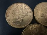 three coins of different sizes and shapes on a black surface