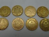a bunch of gold coins sitting on top of a white surface