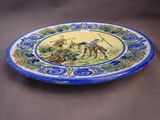 a blue and yellow plate with a picture of a man on a horse