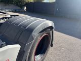 underside of a semi truck with a flat bed and a flat tire