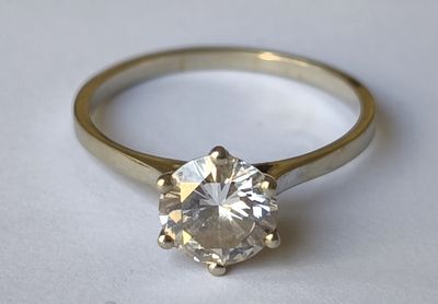 gros plan d'une bague en diamant sur une surface blanche