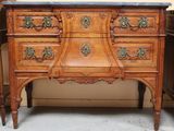a wooden dresser with a marble top on top of it