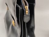 the inside of a black purse with gold zippers on a white background