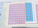 un livre ouvert avec des timbres, posé sur une table