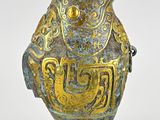 a gold and blue vase with a bird on it