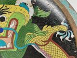a plate with a dragon painted on it on a table