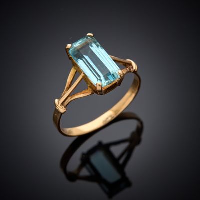 une bague en or sertie d'une topaze bleue au centre