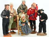 five figurines of people sitting on a chair