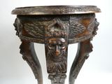 une table en bois sur laquelle est sculpté un visage