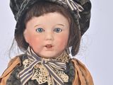 a doll that is wearing a hat and a dress