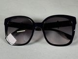des lunettes de soleil « œil de chat » noires posées sur une surface blanche