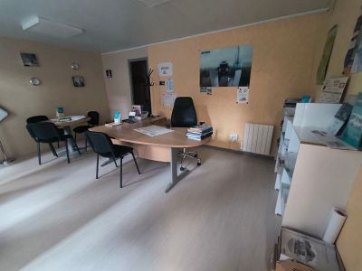 a room with a desk, chairs, and pictures on the wall