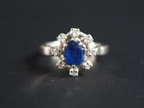 une photo d'une bague sertie d'un saphir bleu et de diamants, posée sur une table