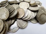 a pile of silver coins on a white surface