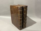 an old book sitting on top of a white table next to a wooden book