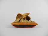 une image représentant une statue d'aigle posée sur un socle en bois