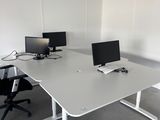 un bureau avec deux ordinateurs et une chaise dans la chambre