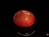 an image of a red stone on a black surface
