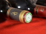 several bottles of wine are lined up on a red cloth
