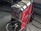 a red and black machine with a hose attached to it