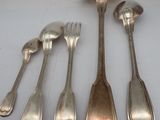 six spoons and a spoon rest on a white surface