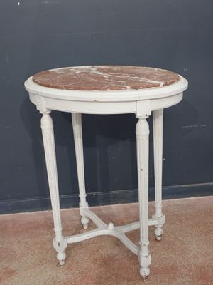 an old white table with a marble top on a carpeted floor