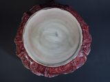 underside view of a red and white bowl on a black surface