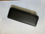 a black leather case sitting on top of a white paper