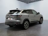 the rear end of a silver suv parked in a garage