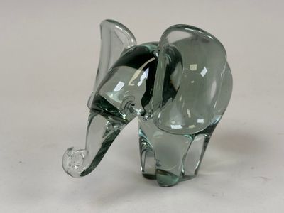 a glass elephant figurine sitting on a white surface