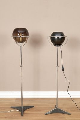trois lampes posées sur un parquet dans une pièce aux murs beiges