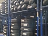 tires stacked on a rack in a warehouse with a lot of them