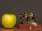 a statue of a dog and an apple on a table