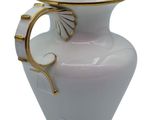 a white vase with a gold handle on a white background