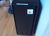 a small black refrigerator next to a desk with a computer on it