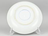a white plate with a blue and yellow rim sitting on top of a table