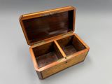 une vieille boîte en bois à deux compartiments posée sur une table
