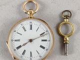 une montre à gousset en or à laquelle est attachée une clé