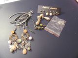 several pairs of earrings sitting on top of a table next to a card