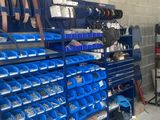 a lot of blue bins on the shelves in the garage