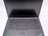 a black laptop with a red keyboard on a white surface