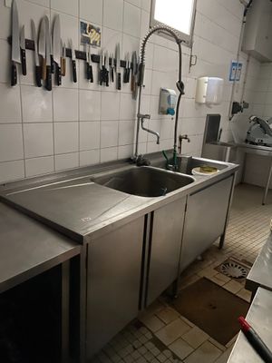 de nombreux couteaux accrochés au mur au-dessus de l'évier de la cuisine