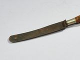 a knife that is sitting on a white surface