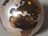 a gold globe sitting on top of a white table