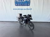 une moto noire garée devant un panneau bleu et blanc