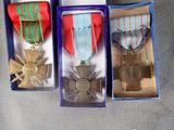 three medals are in a blue box on a gray surface