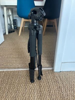 a tripod that is sitting on the floor in front of a door