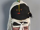 a small doll with a black face and a colorful dress