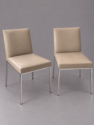 paire de chaises de salle à manger en cuir beige avec des pieds chromés